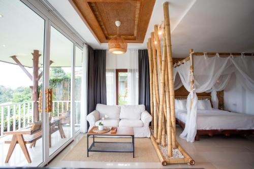 a bedroom with a bed and a couch and a table at Baan Phuvara Retreat - Romantic Jacuzzi Mountain View Villas in Ao Nang Beach
