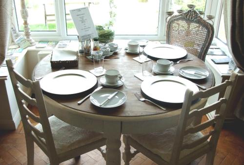 una mesa de madera con platos y cubiertos en Mortimer Trail B and B en Aymestrey