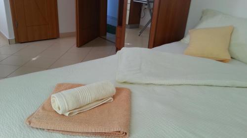 a towel sitting on top of a bed at Apartments Feniks in Pag