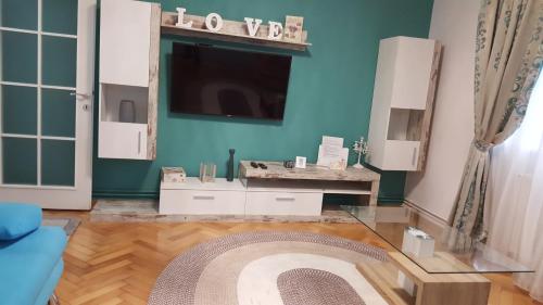 a living room with a tv on a blue wall at Sweet Home in Timişoara