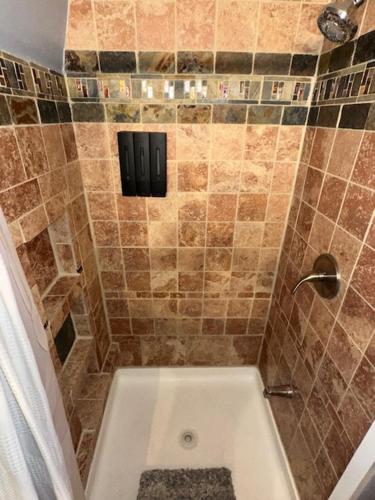 a bathroom with a shower with a bath tub at Cozy Alpine A-Frame in Flagstaff