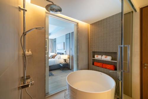a bathroom with a bath tub and a bedroom at Laguna luxury apartment - Bang Tao - lake view in Bang Tao Beach