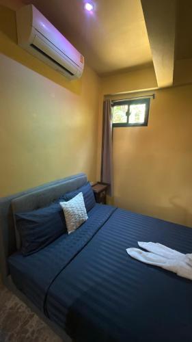 a bedroom with a blue bed with a pillow on it at One bedroom apartment Hin Kong in Ko Phangan