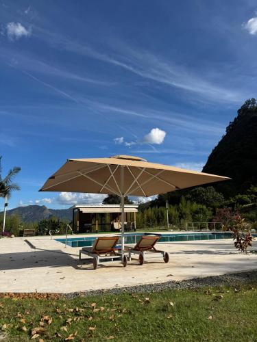 a tan umbrella and two chairs and a pool at Finca Villa Rosita 26 in Copacabana