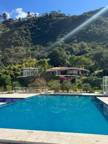 a large blue swimming pool in front of a mountain at Finca Villa Rosita 26 in Copacabana