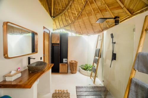 a bathroom with a sink and a mirror at Bamboo Layang Ubud in Ubud
