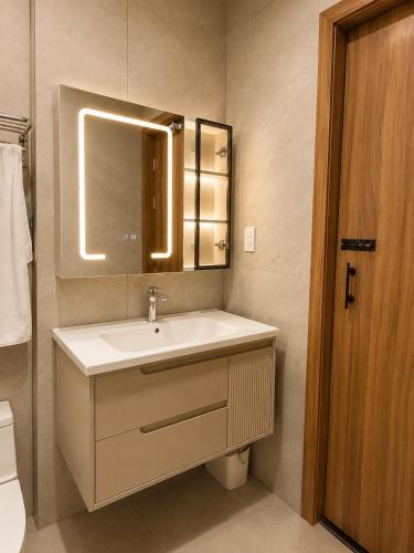 a bathroom with a sink and a mirror at EcoCity Suites BMT in Buôn Enao