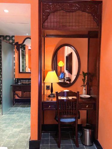 a room with a desk and a mirror at Spatel d'Annam - Imperial Boutique Spa & Hotel in Hue