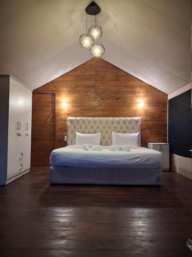 a bedroom with a large bed with a wooden wall at Wilpattu Wilderness Camping in Wilpattu