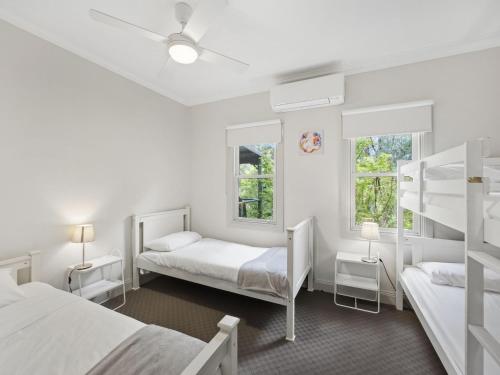a bedroom with two bunk beds and two windows at Woodbine Lodge in Marysville