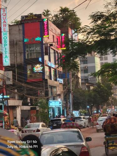 a busy city street with cars and buildings at Hotel The One Point, Uttara in Bāiljuri