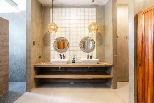 a bathroom with two sinks and two mirrors at Cebu R Resort Tabuelan in Tabuelan