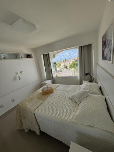a bedroom with a large bed and a large window at Luxus Duplex 102m2 Vista Mar - Vilas do Atlântico in Lauro de Freitas