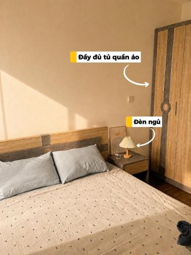a bedroom with a bed and a sign that says day got tha quilt so at HERE Stay in An Khê