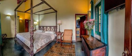 a bedroom with a large canopy bed and a table at Sagala Boutique Hotel in Bandarawela
