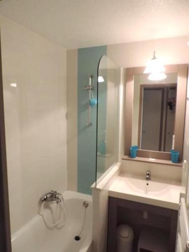une salle de bain avec une baignoire, un lavabo et une douche dans l'établissement Cannes Front Beach Pools Apartment, à Cannes