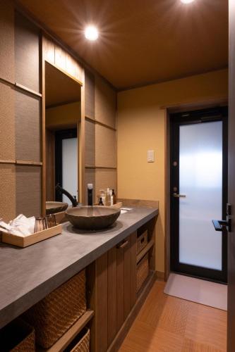 a bathroom with a sink and a large mirror at Temple Stay KAN 観 in Yokosuka