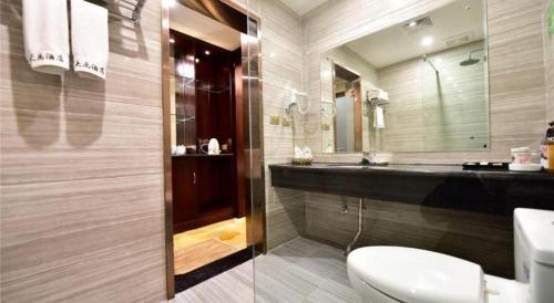 a bathroom with a sink and a toilet and a mirror at Dali Dayu Hotel in Dali