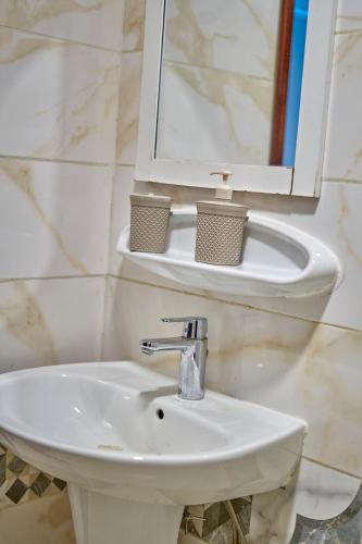 a bathroom with a sink and a mirror at RÉSIDENCE Chloé in Bonamoussadi