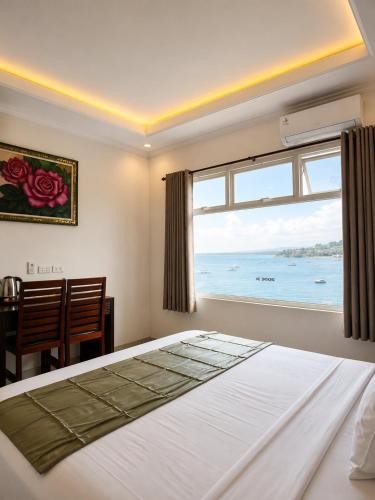 a bedroom with a bed and a large window at Anugrah Hotel Teluk Nara in Teluknarat