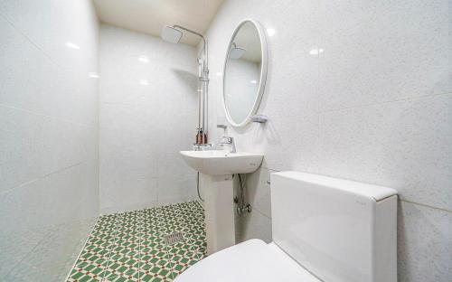 a bathroom with a toilet and a sink and a mirror at Dapsimni Hotel Grim in Seoul