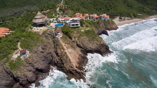 an aerial view of a house on a cliff next to the ocean at Hotel Punta Serena & Resorts - Solo Parejas in Tenacatita