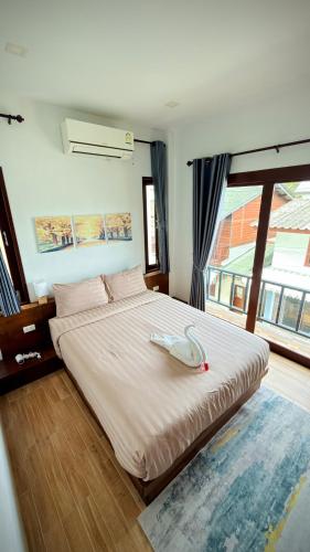 a large bed in a room with a large window at Happy House in Chaloklum in Chaloklum