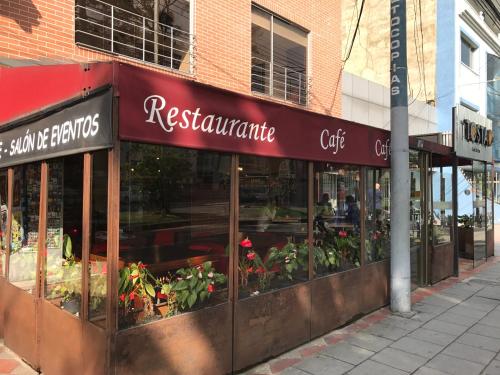 un restaurante con plantas en las ventanas de un edificio en Hotel Dorado Gold en Bogotá