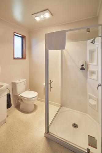 a bathroom with a toilet and a glass shower at Glentanner Park Centre in Glentanner