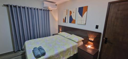 a bedroom with a bed with blue shoes on it at Cabañas MI REFUGIO TERMAL in Roboré