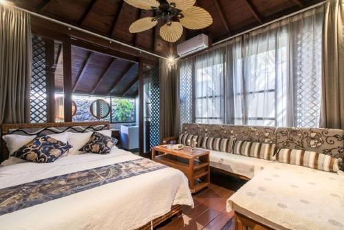 a bedroom with two beds and a ceiling fan at 三亚亚龙湾伊墅情怀旅租 in Sanya