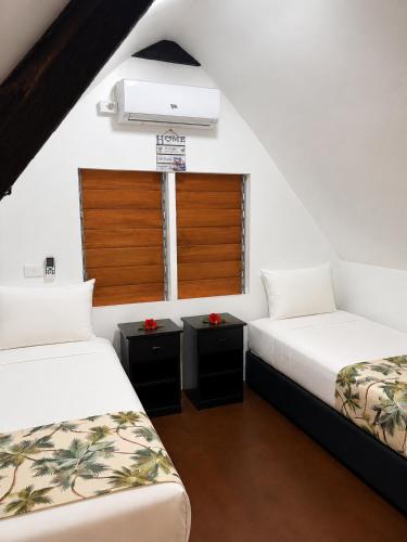 two beds in a room with a window at Crusoe's Retreat - Family Friendly in Namanggumanggua