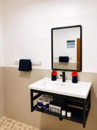a bathroom with a white sink and a mirror at Crusoe's Retreat - Family Friendly in Namanggumanggua