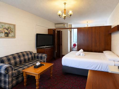 a hotel room with a bed and a couch at Pathfinder Motel in Melbourne