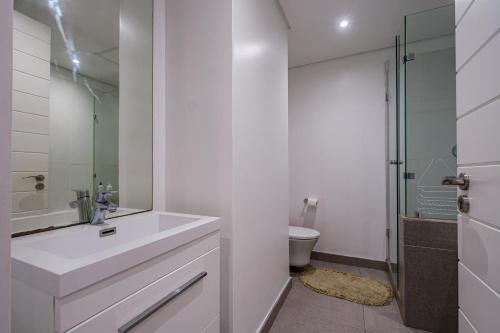 a white bathroom with a sink and a toilet at Ocean Vista Pebble Beach in Umhlanga