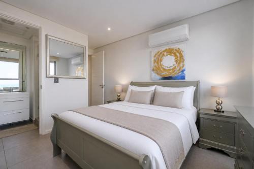 a bedroom with a large bed and a mirror at Ocean Vista Pebble Beach in Umhlanga