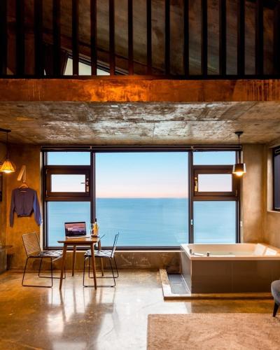 a large room with a tub and a table and a table sidx sidx at Samcheok Laon Spa Pension in Samcheok