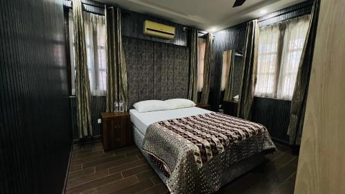 a bedroom with a bed in a room with windows at Borrow and Pay in Heṭauḍā