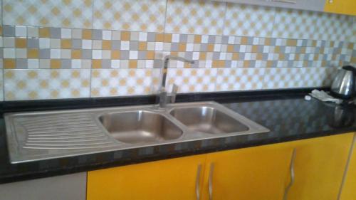 a kitchen sink with a faucet on top of it at maison djerbienne in Fafou