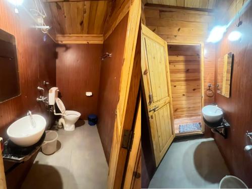 a bathroom with a toilet and a sink and a tub at Village Sunset Paradise Beach Resort in Morjim