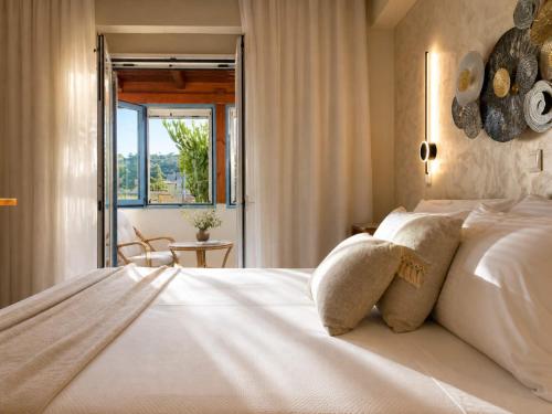 a bedroom with a large white bed with a window at Villa Kallergi Nefeli in Loutra