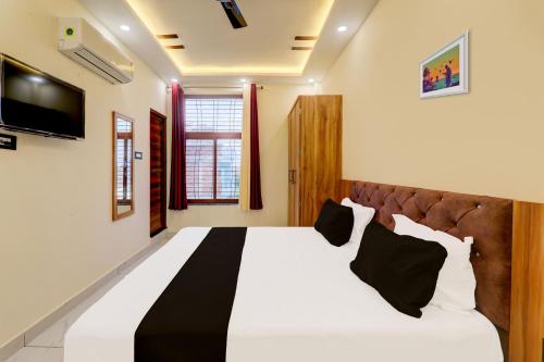 a bedroom with a large white bed with black pillows at Hotel manyam palace in Gorakhpur