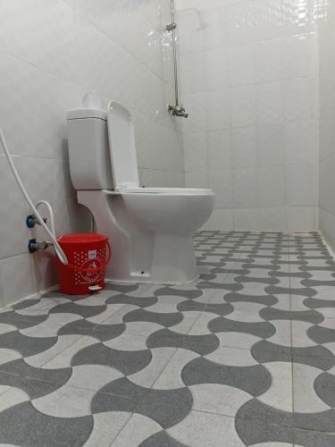 a bathroom with a toilet and a black and white floor at Casa twende A in Nungwi