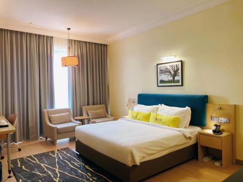 a hotel room with a bed and a chair at UCSI Hotel Kuching in Kuching