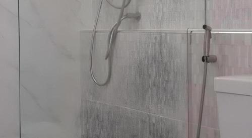 a shower with a shower head in a bathroom at Ceniq Hotel in Sathani Nakhon Lampang