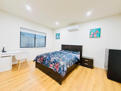 ein Schlafzimmer mit Bett, Schreibtisch und Fenster in der Unterkunft Premier Suite with Private Bathroom in Wyndham Vale