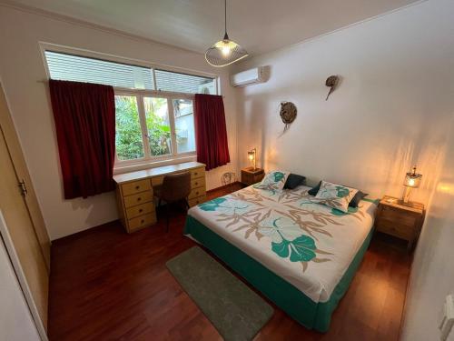 a bedroom with a bed and a window at SCO Lodge in Punaauia
