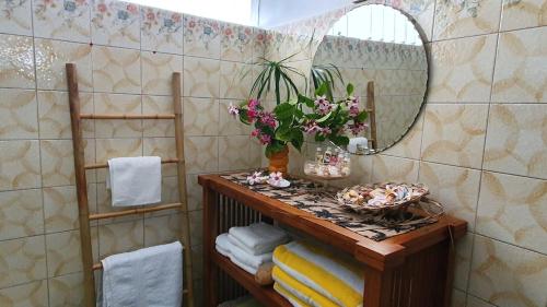a bathroom with a table with a mirror and towels at SCO Lodge in Punaauia