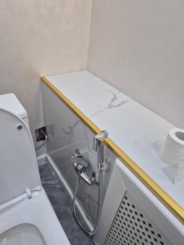 a bathroom with a white toilet and a sink at На Желтоксан in Taldykorgan