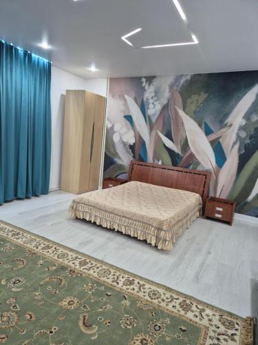 a bedroom with a bed and a painting on the wall at На Желтоксан in Taldykorgan